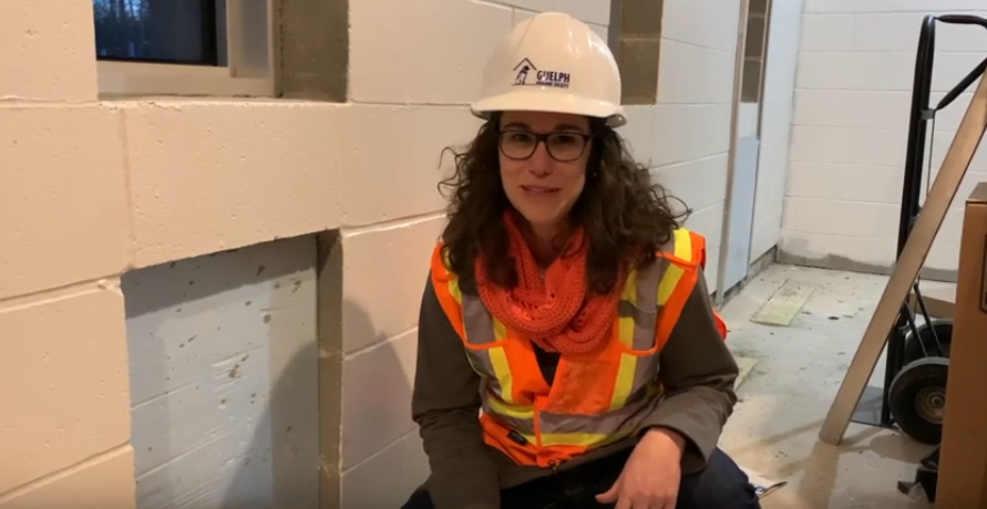Adrienne, wearing a hard hat and safety vest, at a construction site