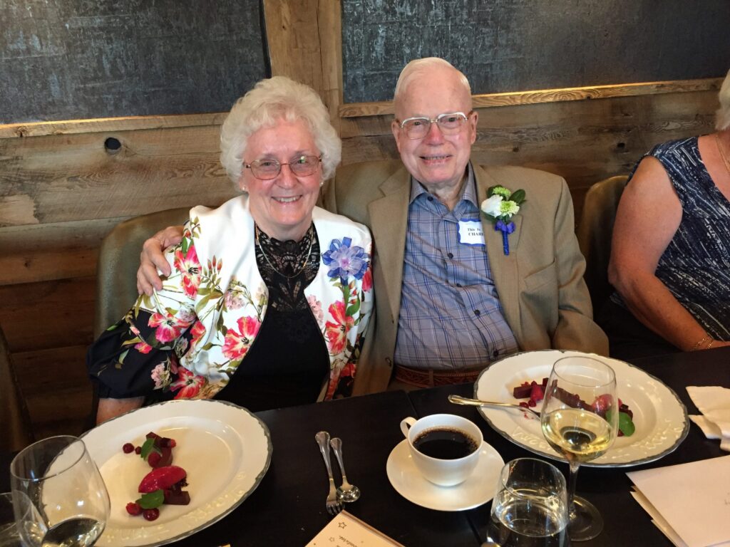 Charlie Millage, seated beside a woman at a dinner table, celebrating his 94th birthday at the Elora Mill