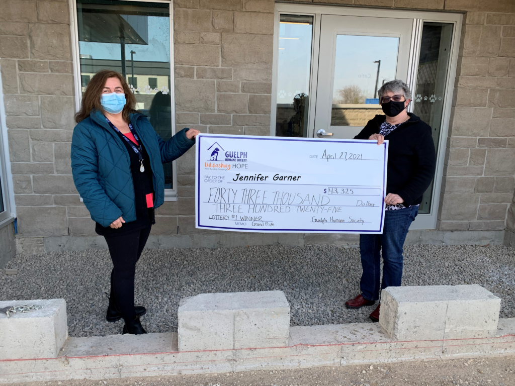 Jennifer Garner, winner of the GHS Spring 50/50 lottery, holding an oversized cheque with a GHS staff member