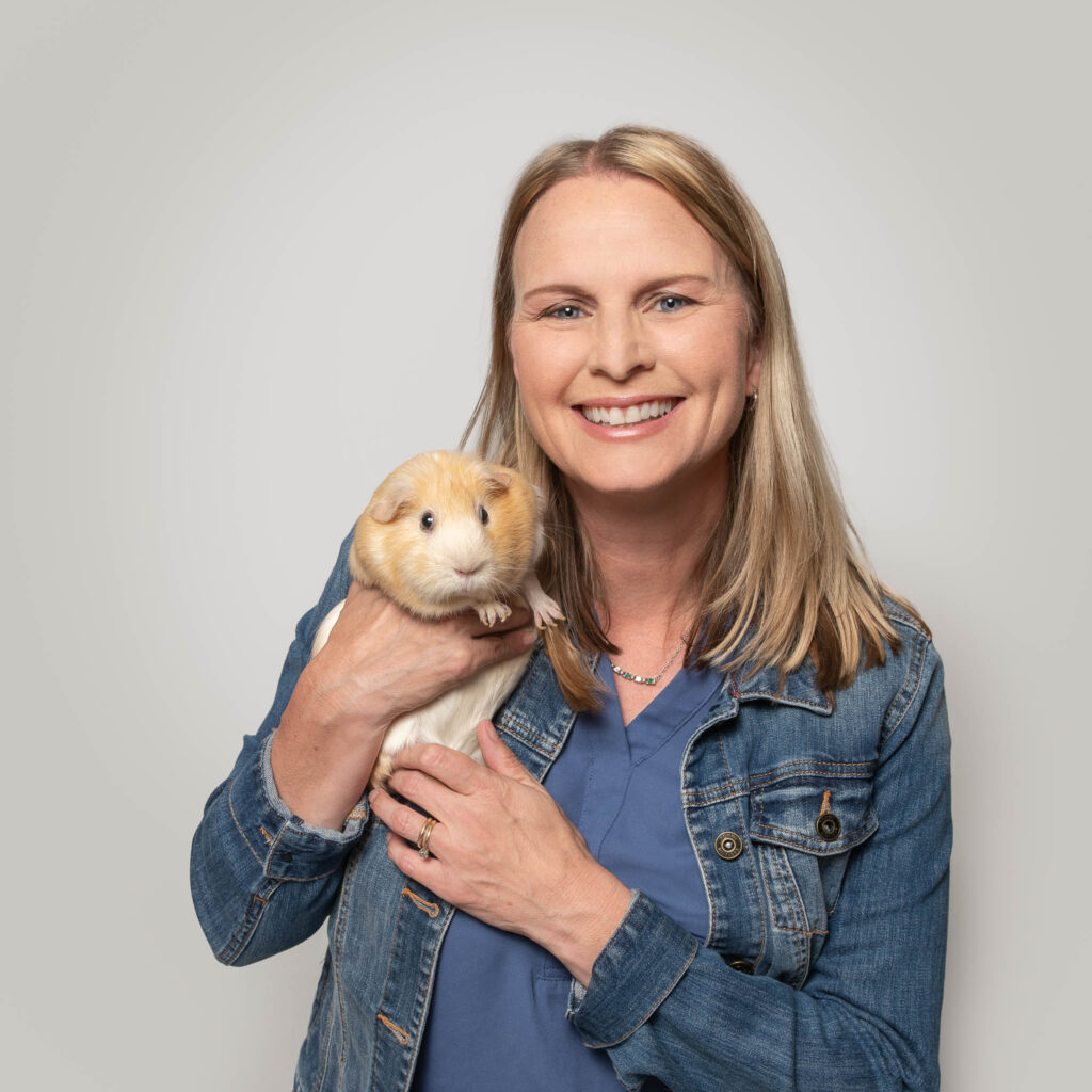 Lisa smiling while holding her guinea pig, Daisy