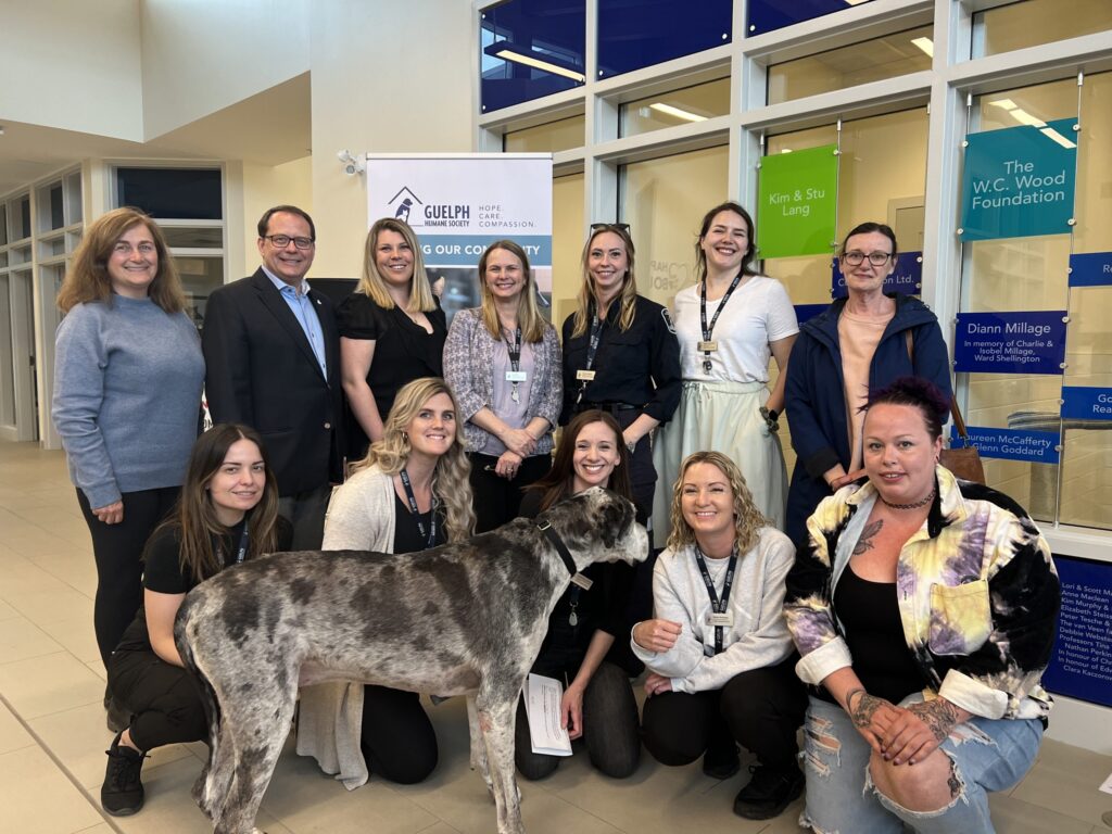 GHS staff and community partners, including MPP Mike Schreiner, posing with Marcus, an adoptable dog