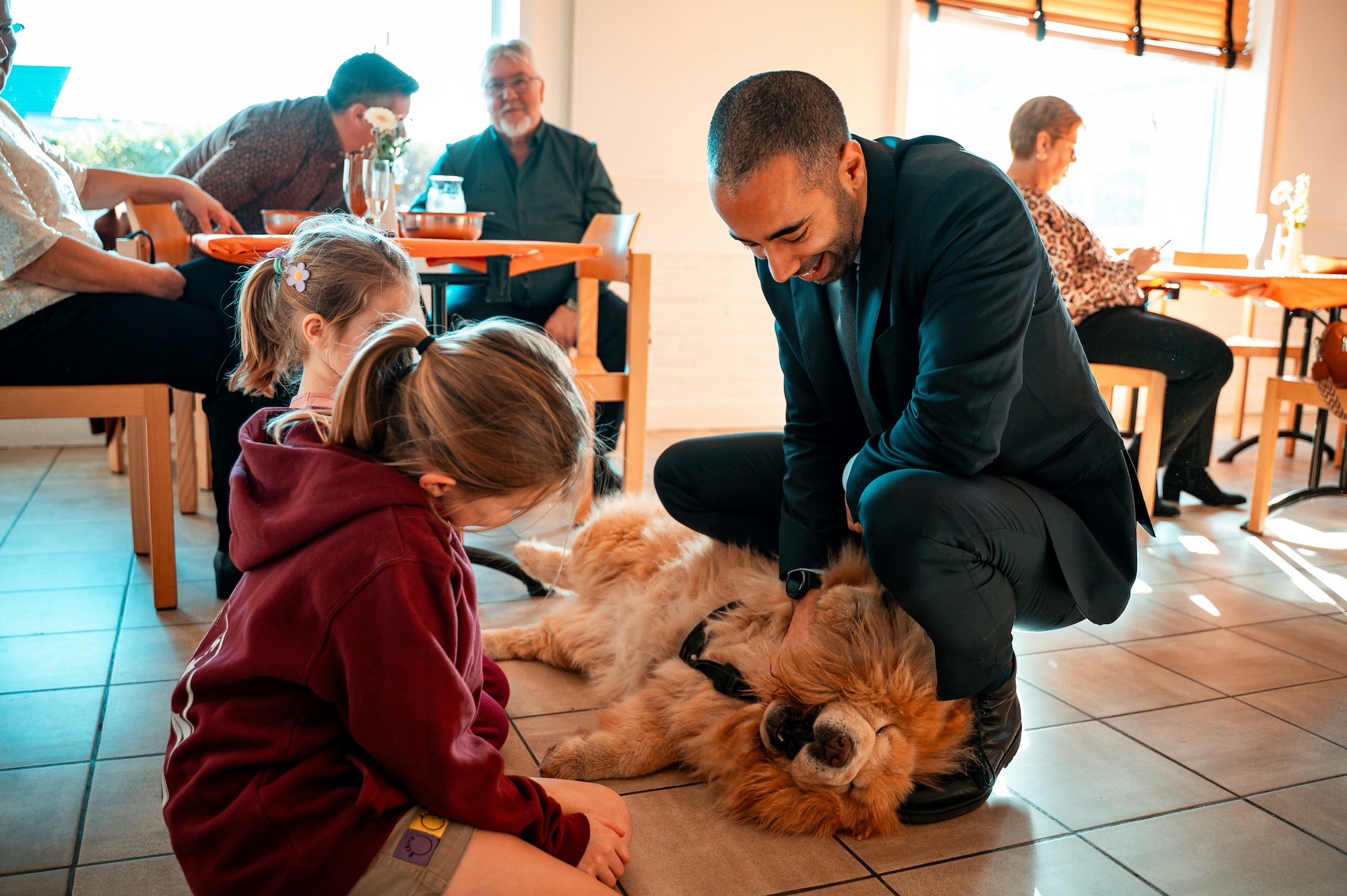 a group of people petting a dog on the floor