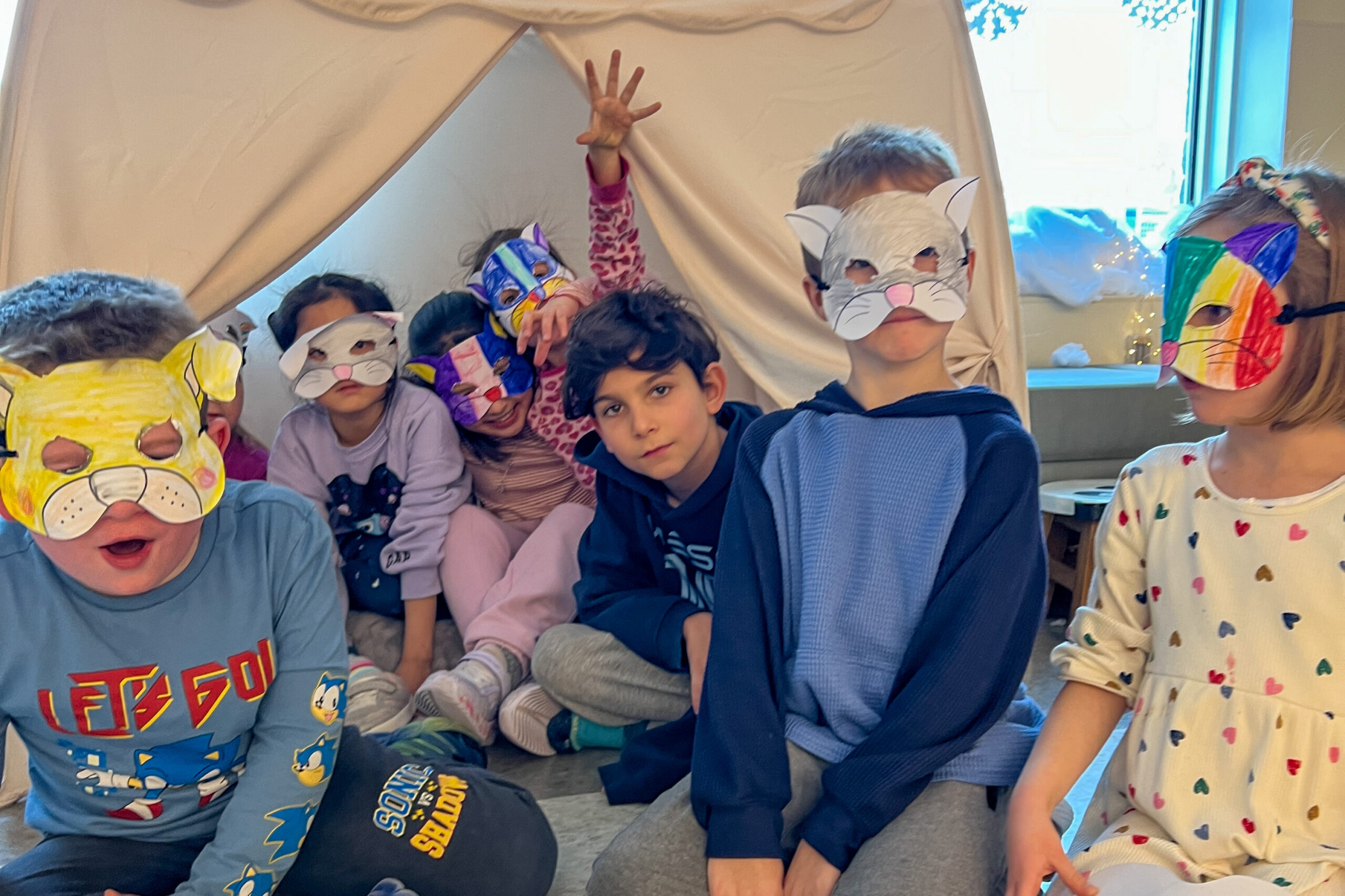 Children wearing paper animal masks they made, posing together
